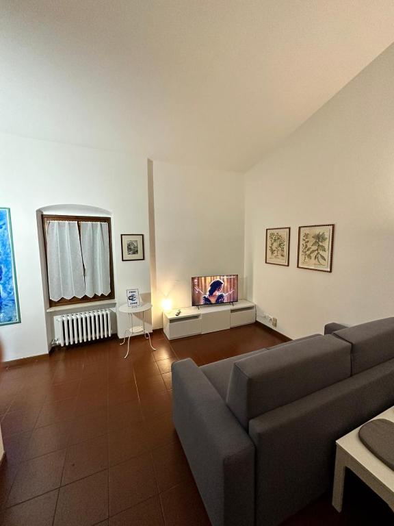 a living room with a couch and a tv at Dreaming Borgo Roma Apartment in Verona