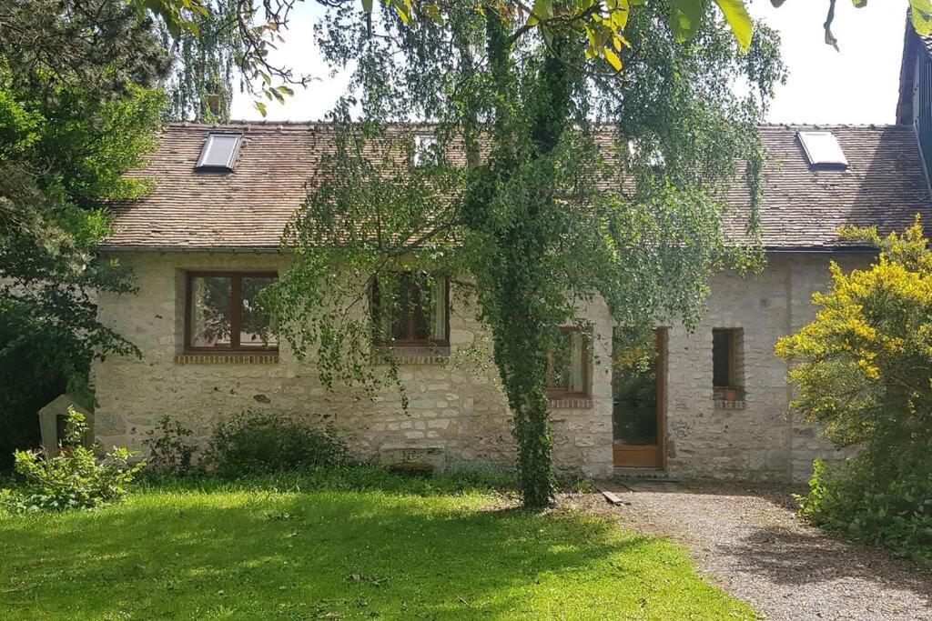 una vieja casa de piedra con un árbol delante en La Casita de BEMI en Bois-Jérôme-Saint-Ouen