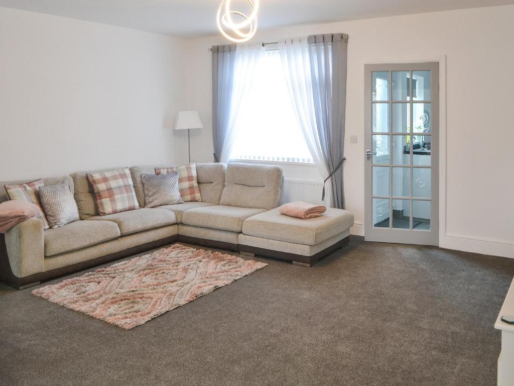a living room with a couch and a rug at Bracken Dene in Cresswell
