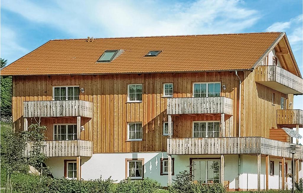 ヴィヒタッハにあるFerienpark Schwarzholzのバルコニー付きの大きな木造の建物