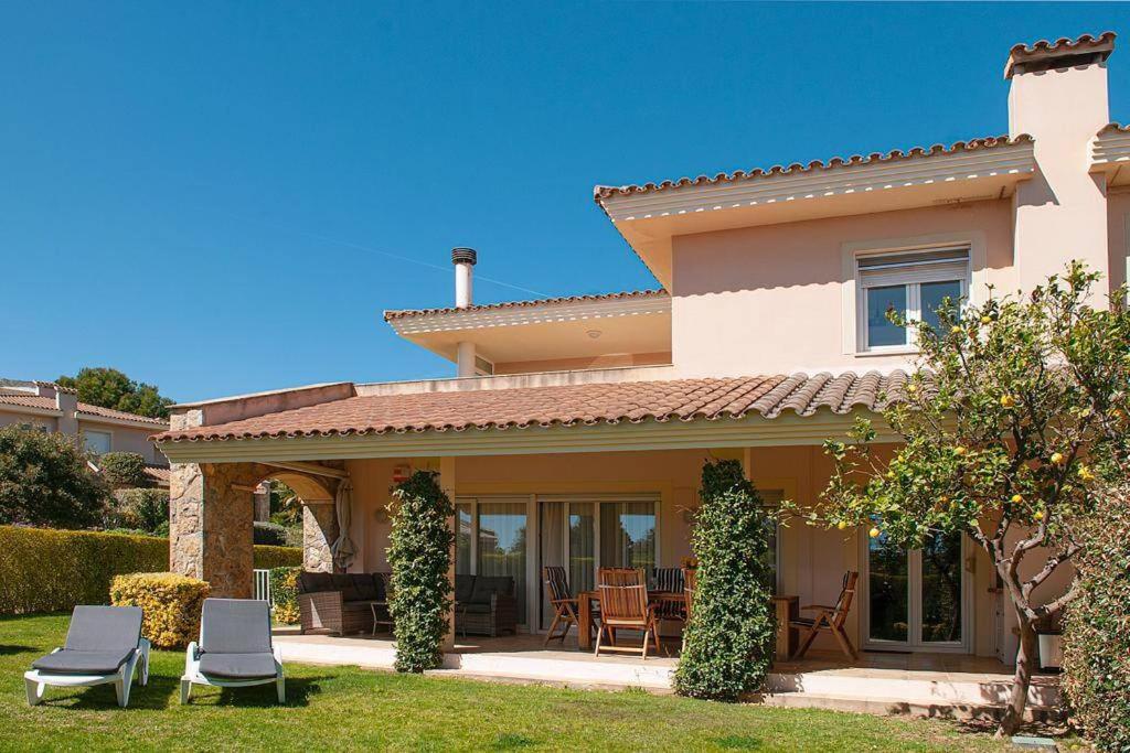 una casa con patio y sillas en el patio en Naturaleza, Playa, Montaña, Golf, en Bonmont Terres Noves