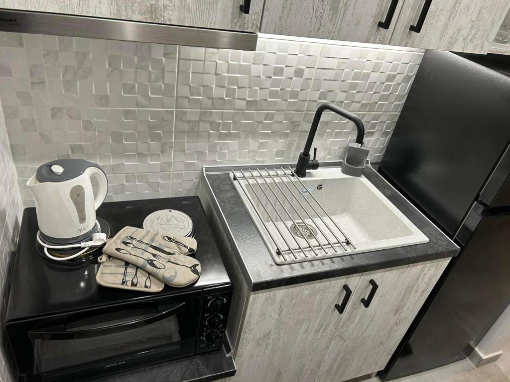 a small kitchen with a sink and a microwave at MSK Rotonda Studio 1 in Thessaloniki