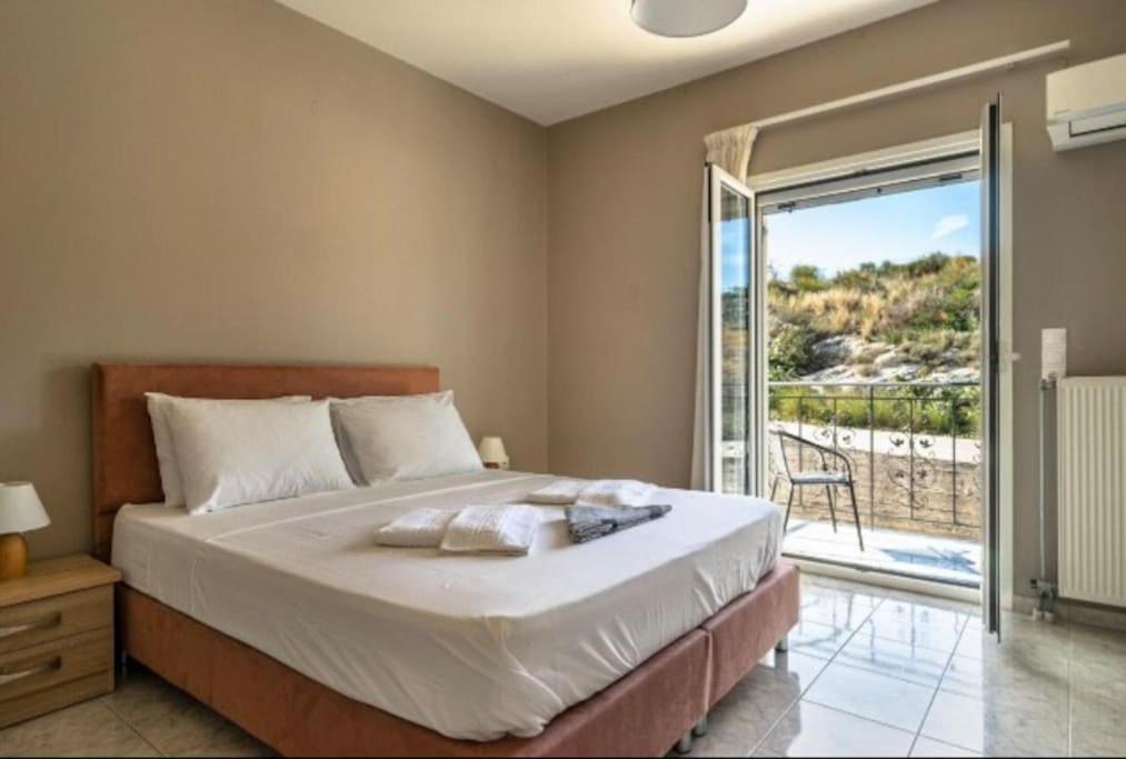 a bedroom with a large bed and a balcony at Grand view resort in Argostoli
