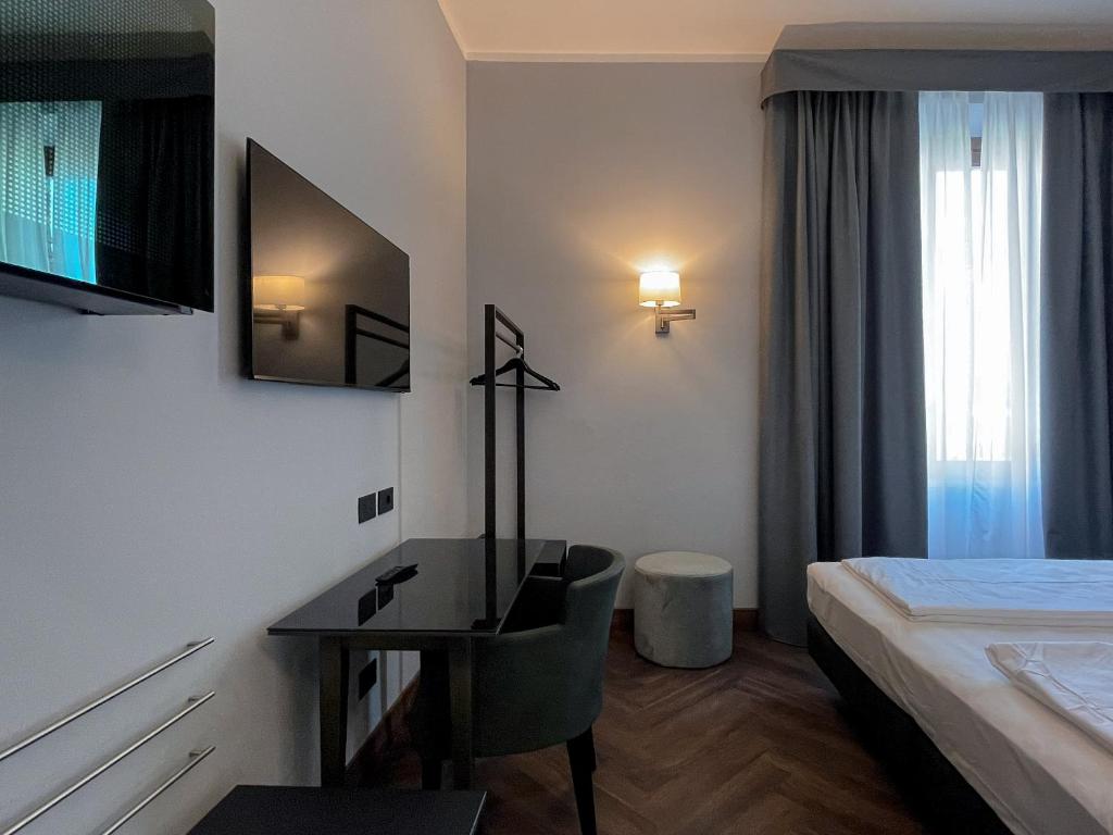 a hotel room with a desk and a bed at Hotel Impero in Cremona
