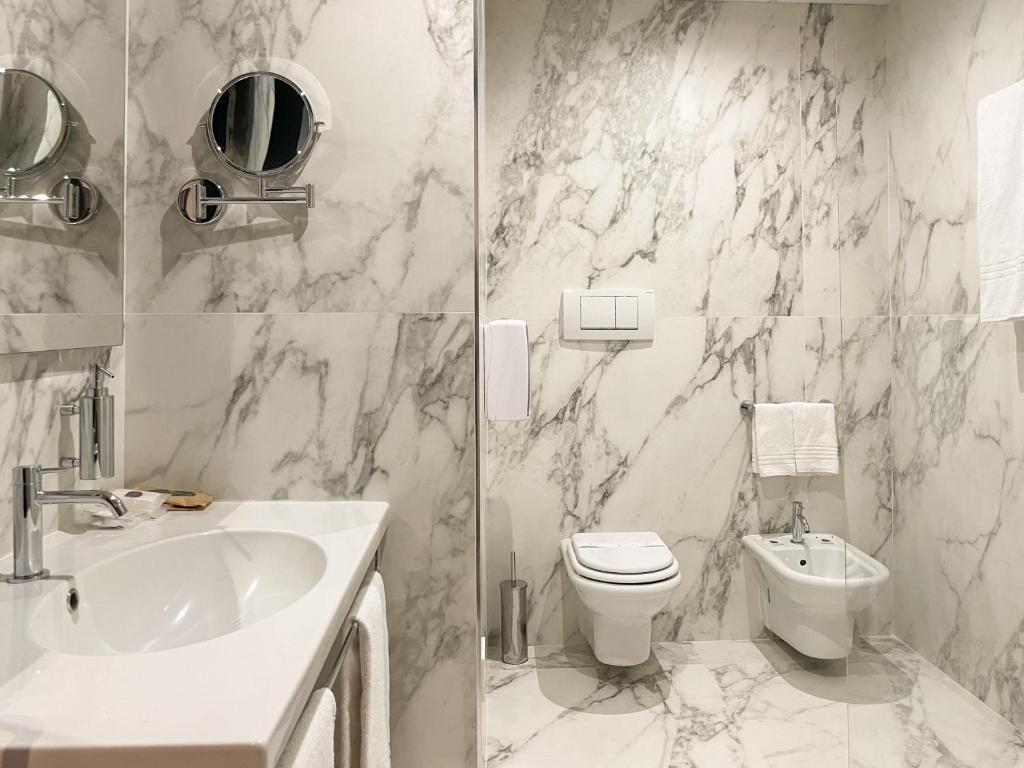 two pictures of a bathroom with a sink and a toilet at Hotel Impero in Cremona