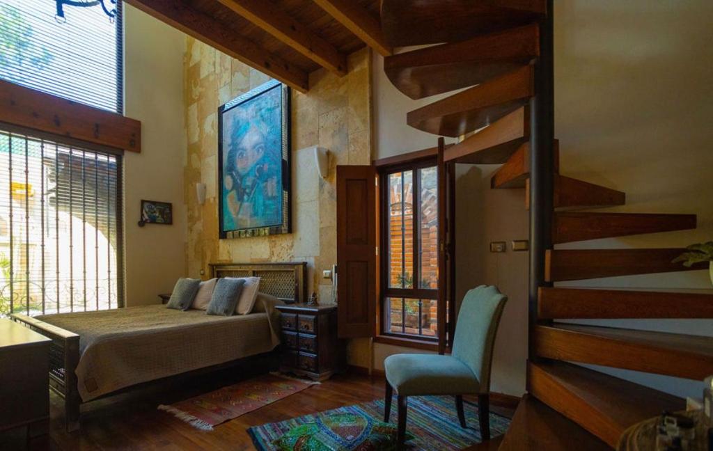 een slaapkamer met een bed en een trap in een kamer bij Preciosa casa La Tolina en Puebla in Santa María Tonantzintla