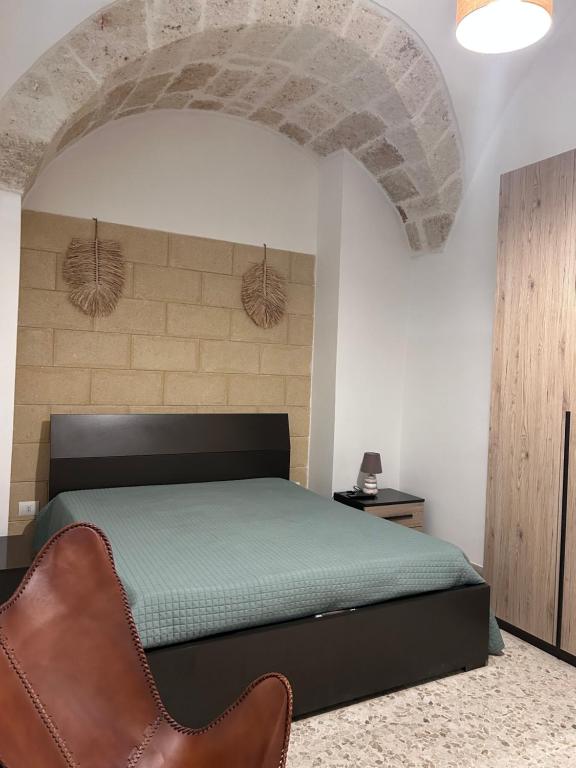 a bedroom with a bed and a chair at Annandre in Polignano a Mare
