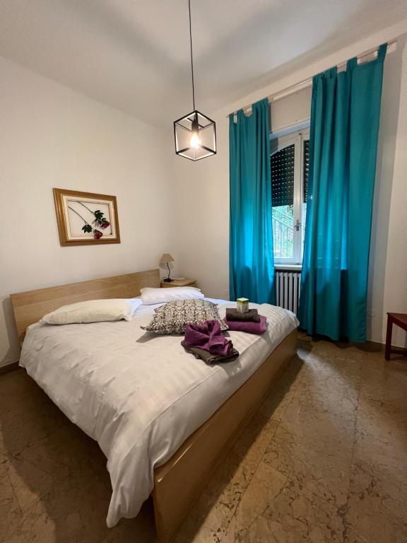 トッリ・デル・ベーナコにあるVilla CorteOlivo Roomsのベッドルーム1室(青いカーテン付きの大型ベッド1台付)