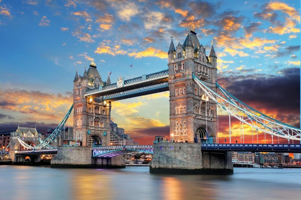 un puente colgante en Londres sobre el agua al atardecer en The Grand M London city, en Londres