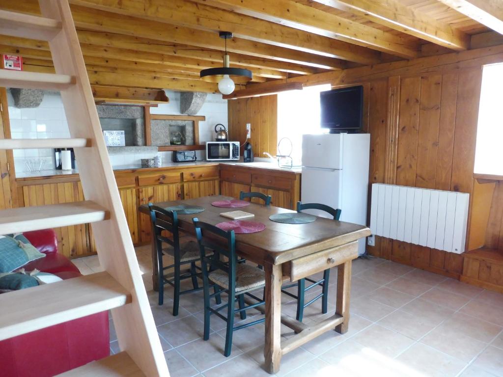 a kitchen with a table and chairs and a refrigerator at La ch&#39;tiote meizou in Mazet-Saint-Voy