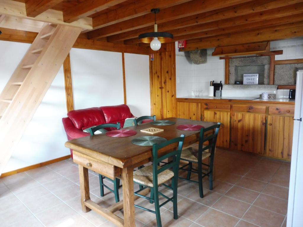 a kitchen and dining room with a wooden table and chairs at La ch&#39;tiote meizou in Mazet-Saint-Voy