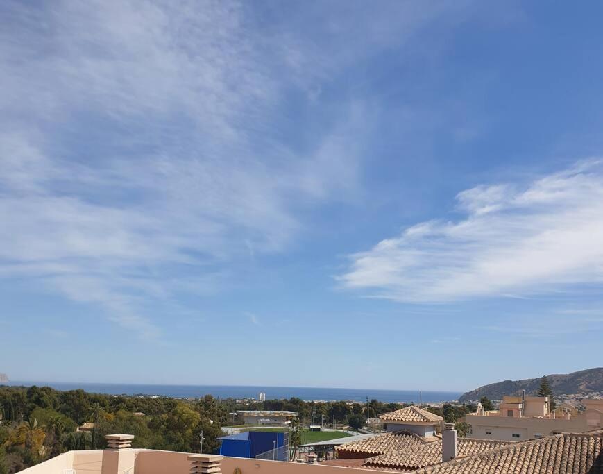 a cloudy blue sky with buildings and trees at Apartamento en casco antiguo in Alfaz del Pi