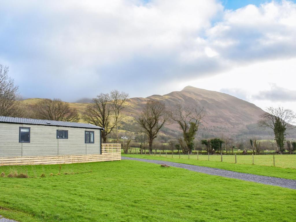 a building in a field with a mountain in the background at Dodd - Uk42499 in Bassenthwaite
