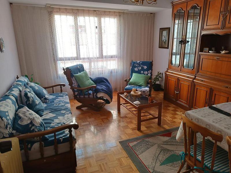 een woonkamer met een bank en 2 stoelen bij Piso centro Luanco in Luanco