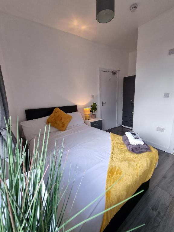 Un dormitorio con una cama grande y una planta en 23 Woodhouse en Stoke on Trent