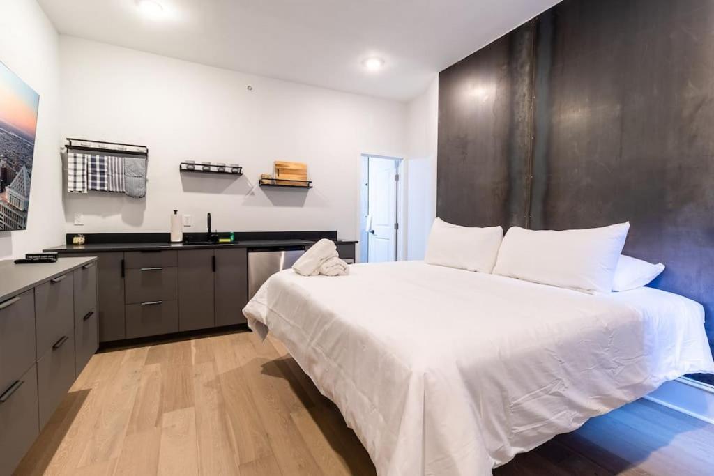1 Schlafzimmer mit einem großen weißen Bett und einer Küche in der Unterkunft Thena Hotel- Lux Studio in Philadelphia