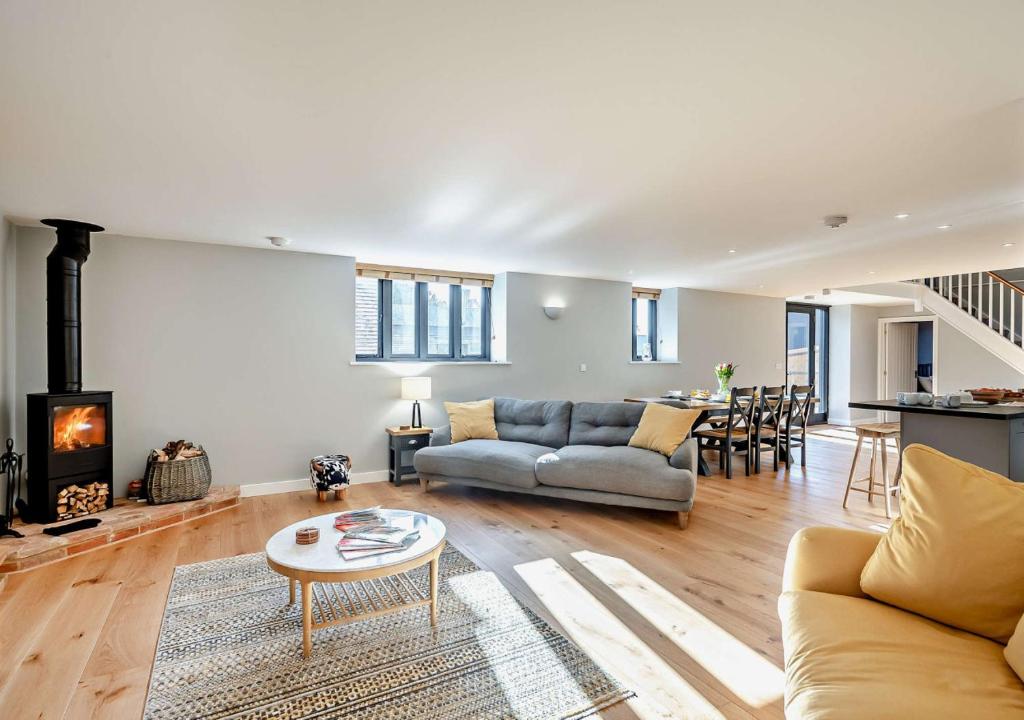 a living room with a couch and a fireplace at The Oat Barn in Hawkedon