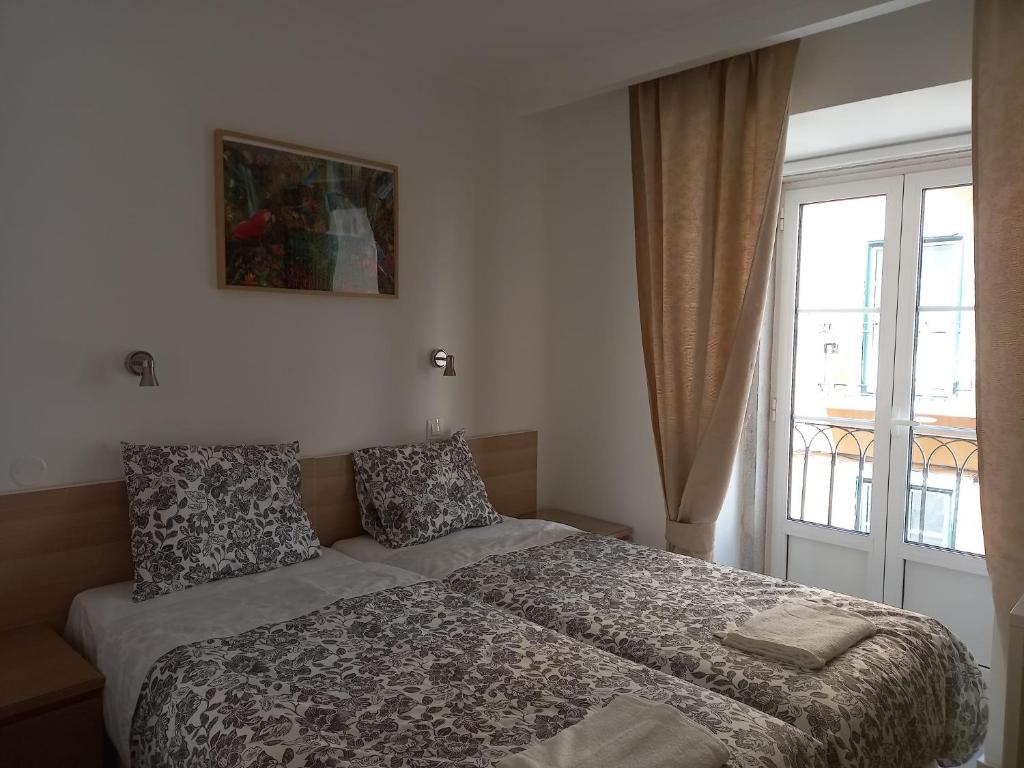- une chambre avec un lit, une fenêtre et une fenêtre dans l'établissement CityInn Suites, à Lisbonne