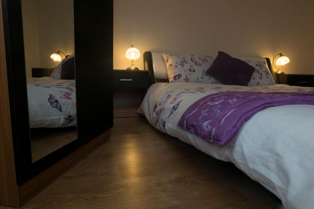 a bedroom with two beds and a mirror at Lovely Master Bedroom with King Size Bed in Liverpool
