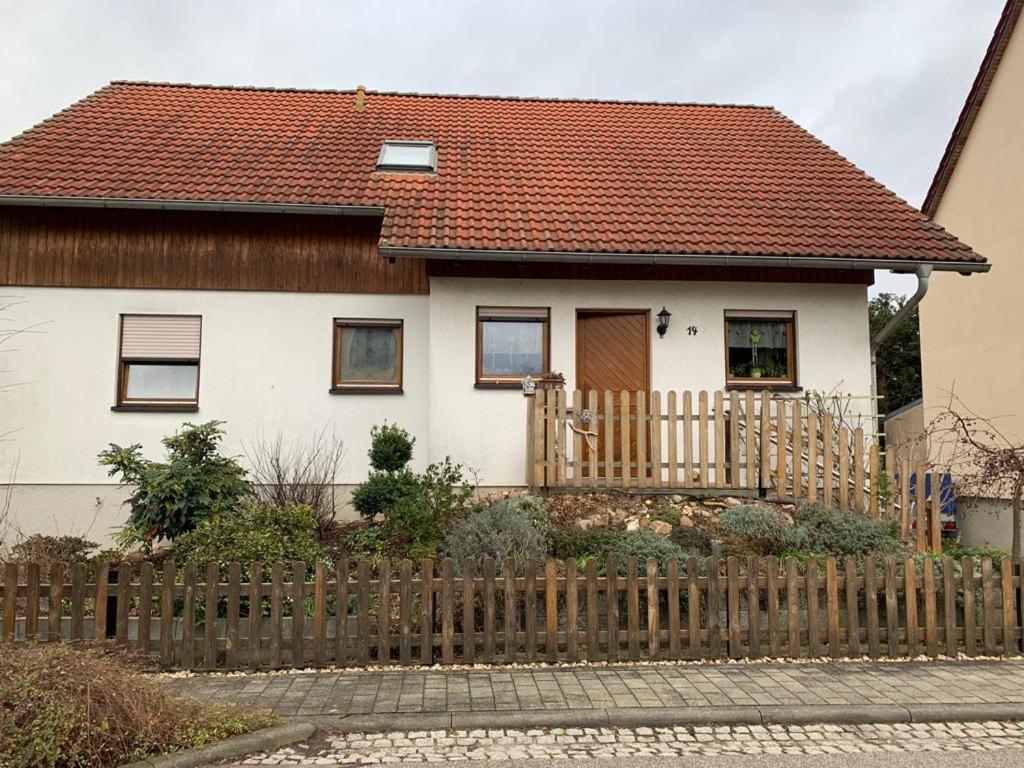 a house with a wooden fence in front of it at Ferienwohnung Am Froschteich in Markranstädt