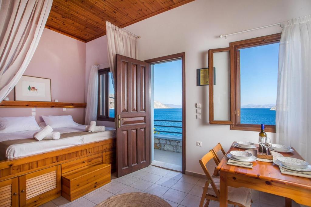 a bedroom with a bed and a table and a desk at Margaritas apartments in Symi