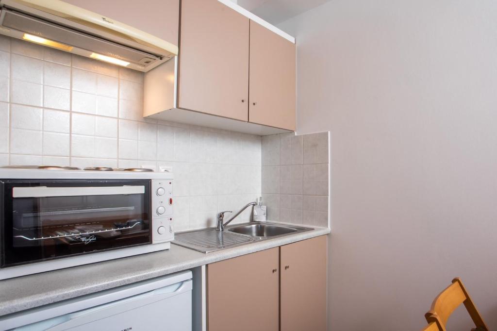 a kitchen with a sink and a microwave at Margaritas apartments in Symi