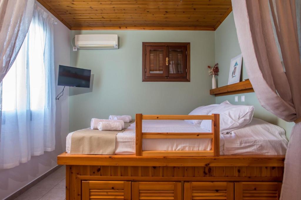 a bedroom with a bed with a tv and a window at Margaritas apartments in Symi