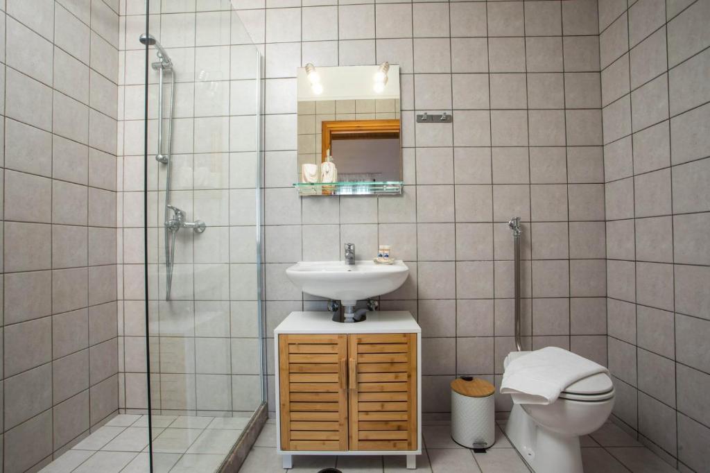 a bathroom with a sink and a shower and a toilet at Margaritas apartments in Symi