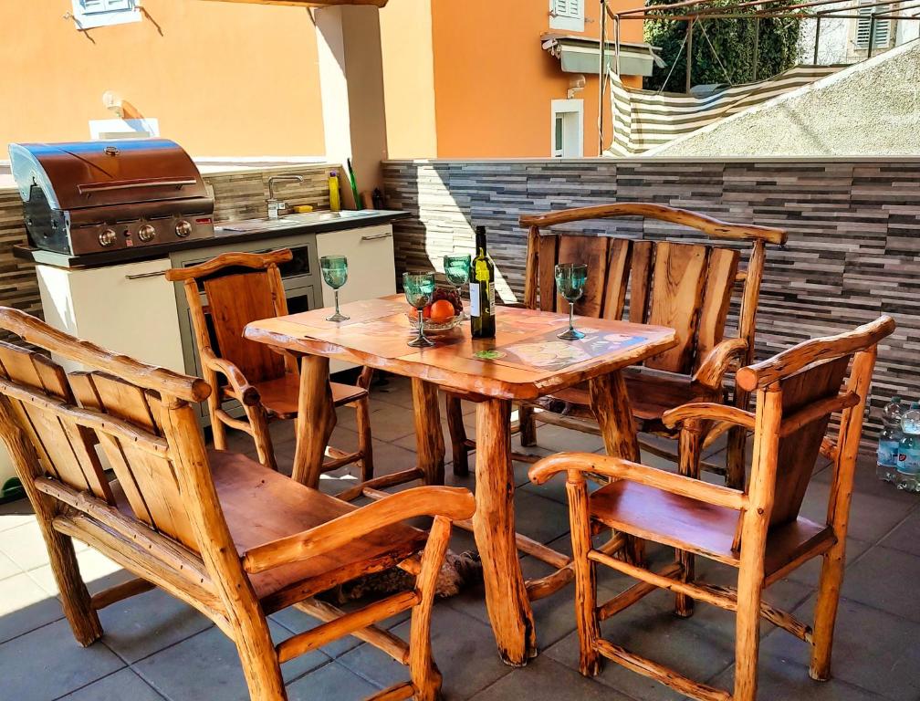un tavolo e sedie in legno su un patio di Ferienhaus Maja - a76148 a Pavicini