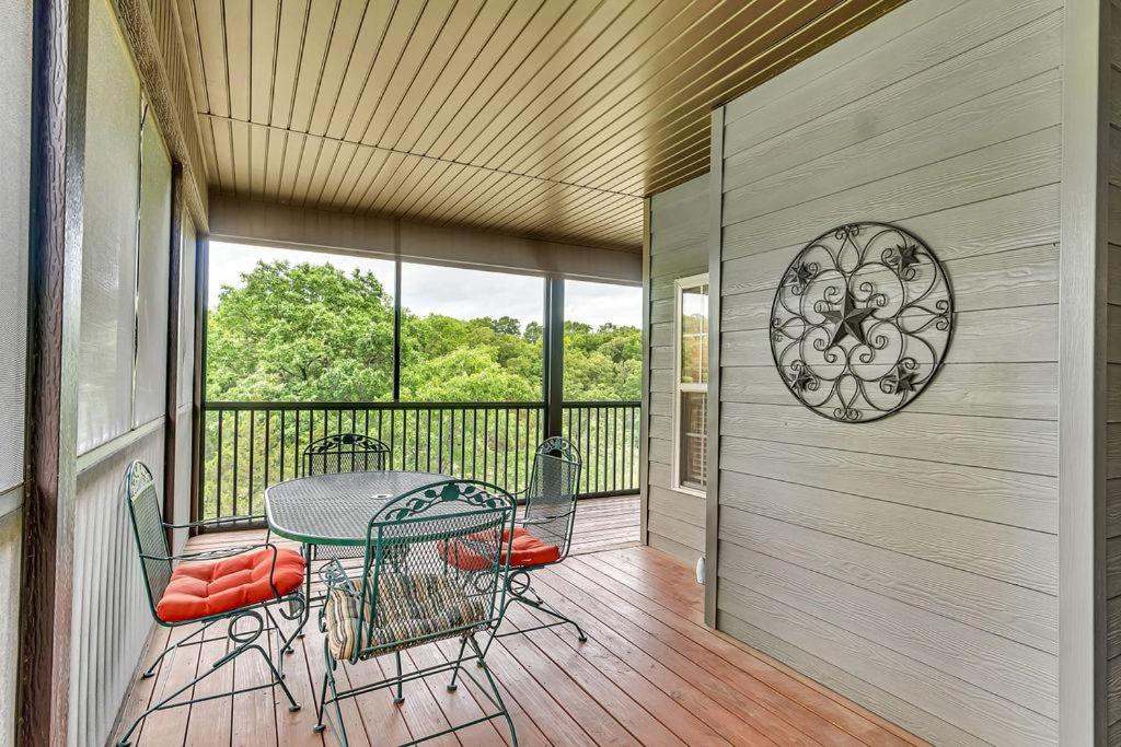 a porch with a table and chairs on a balcony at Paradise on the Fairway in Reeds Spring