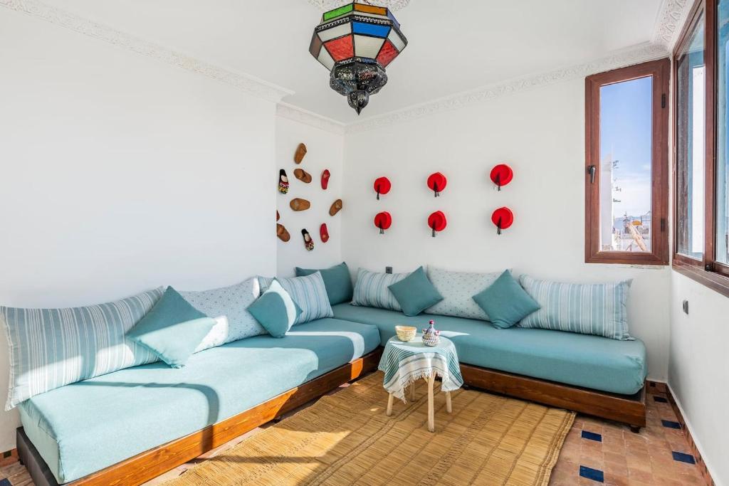 un soggiorno con divano blu e tavolo di DAR ADIL KASBAH a Tangeri