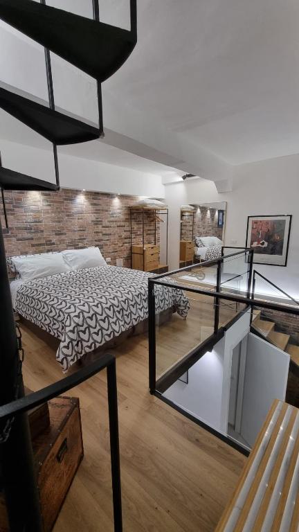 sypialnia z łóżkiem i ceglaną ścianą w obiekcie Home Catania Dante Accommodations w Katanii
