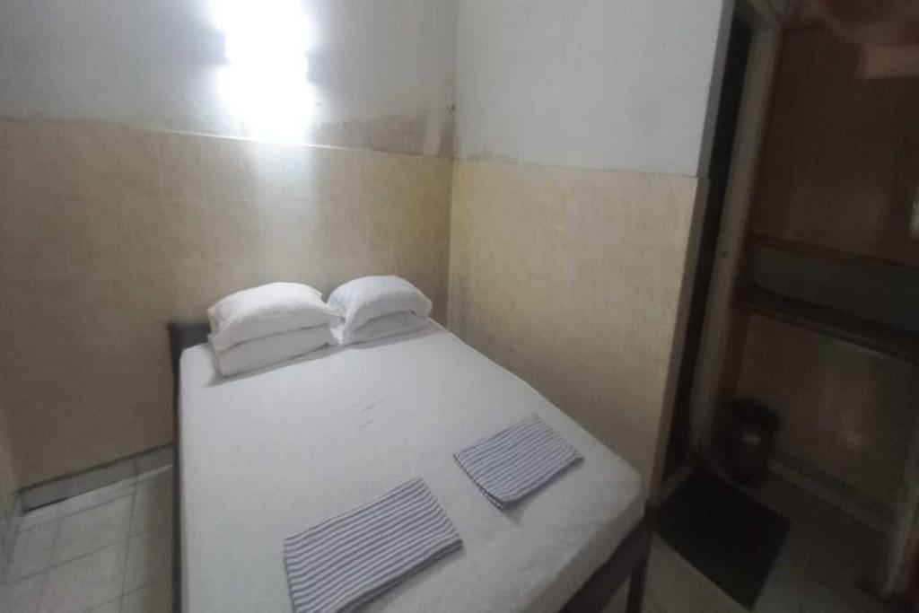 Cette petite chambre comprend un lit avec des serviettes. dans l'établissement SPOT ON 92434 Puri Kasih Guest House Syariah, à Solo