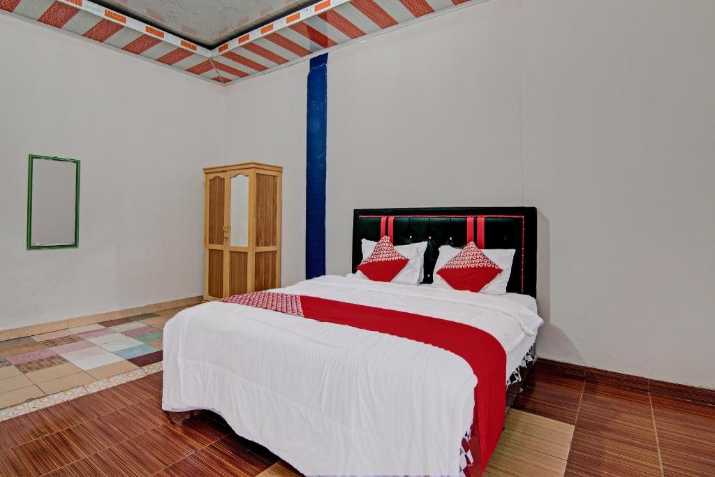 a bedroom with a large bed with red pillows at OYO 92455 Hadhilfa Homestay Syariah in Pekanbaru