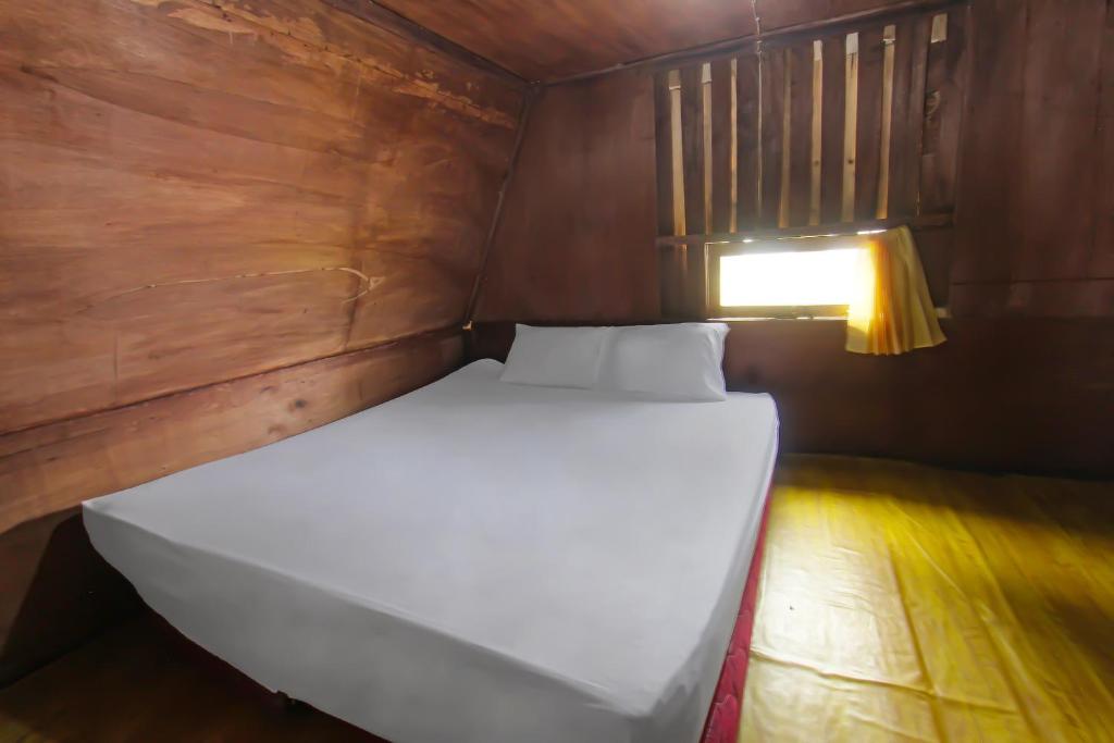 a large white bed in a room with a light at SPOT ON 92462 Awenk Homestay in Lombok