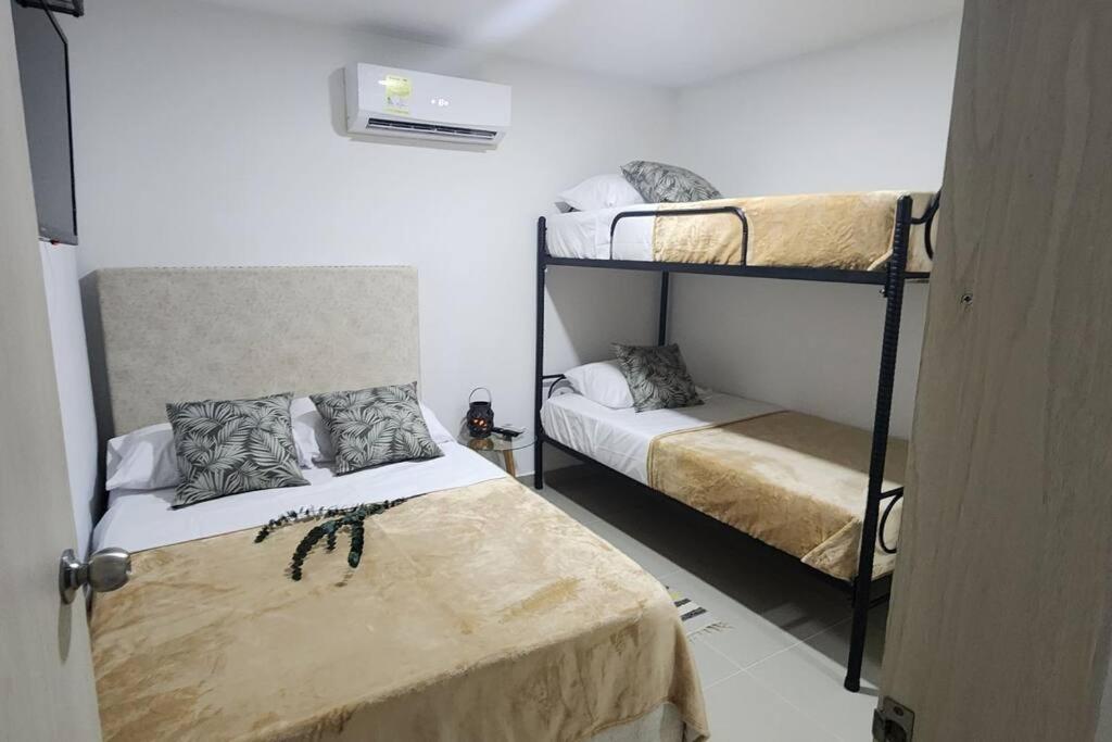 Zimmer mit 2 Etagenbetten in einem Zimmer mit einer Tür in der Unterkunft Genial apartamento de playa! coveñas in Coveñas