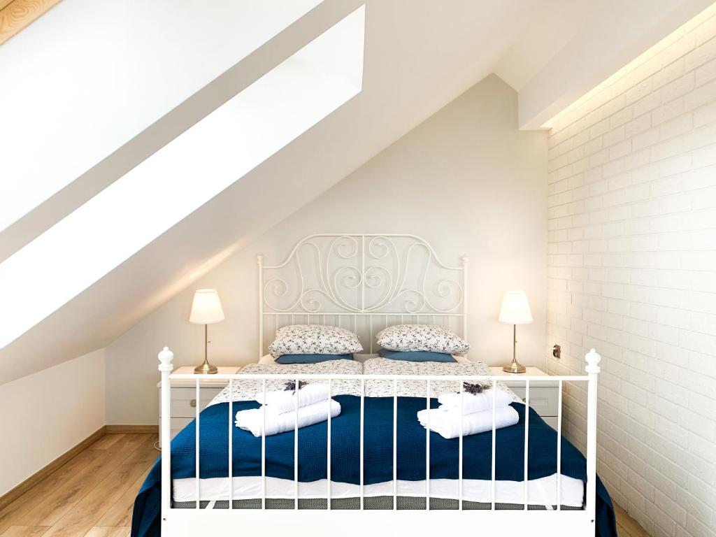 レバにあるNawrotówkaのベッドルーム(白と青のシーツが入った白いベッド付)