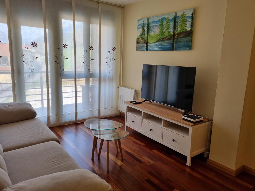 ラス・アレーナス・デ・カブラレスにある24A01 Apartamento Cabralesのリビングルーム(ソファ、テレビ付)