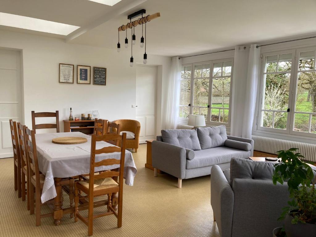 a living room with a table and a couch at Gîte La Maison de JuJu in Lacave