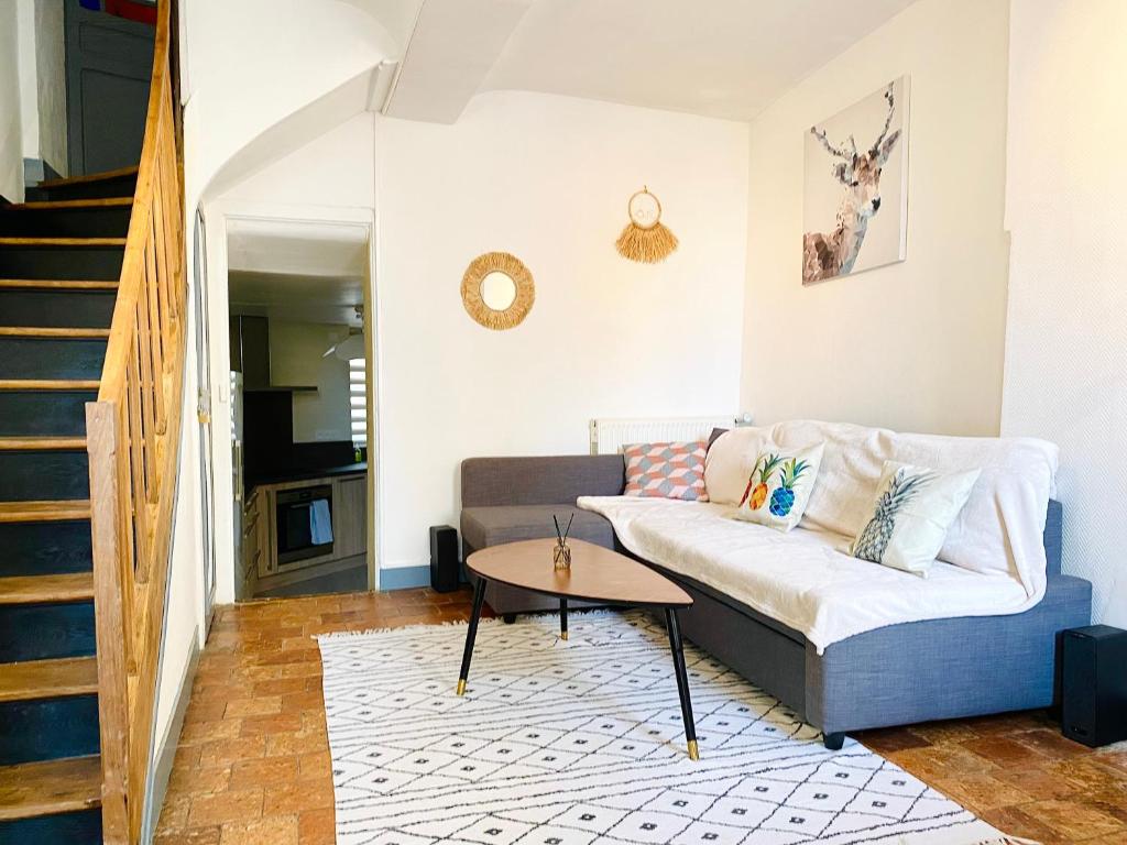 a living room with a couch and a table at La persienne Bleue - Coeur historique de Mortagne au Perche in Mortagne-au-Perche
