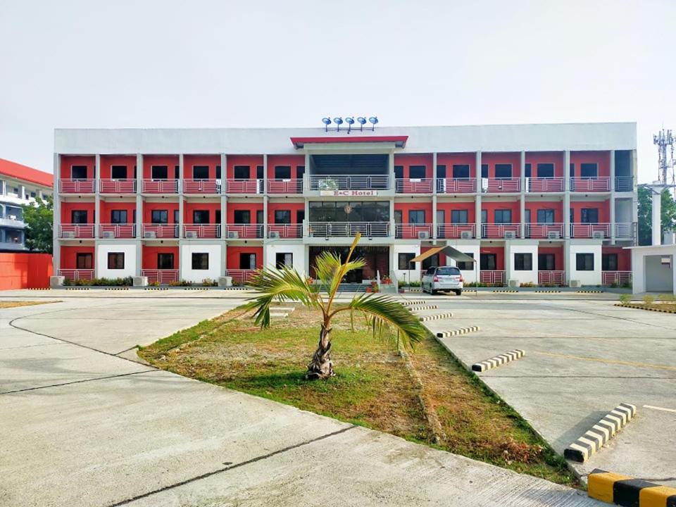 ein großes Gebäude mit einer Palme davor in der Unterkunft E & C Hotel in Laoag