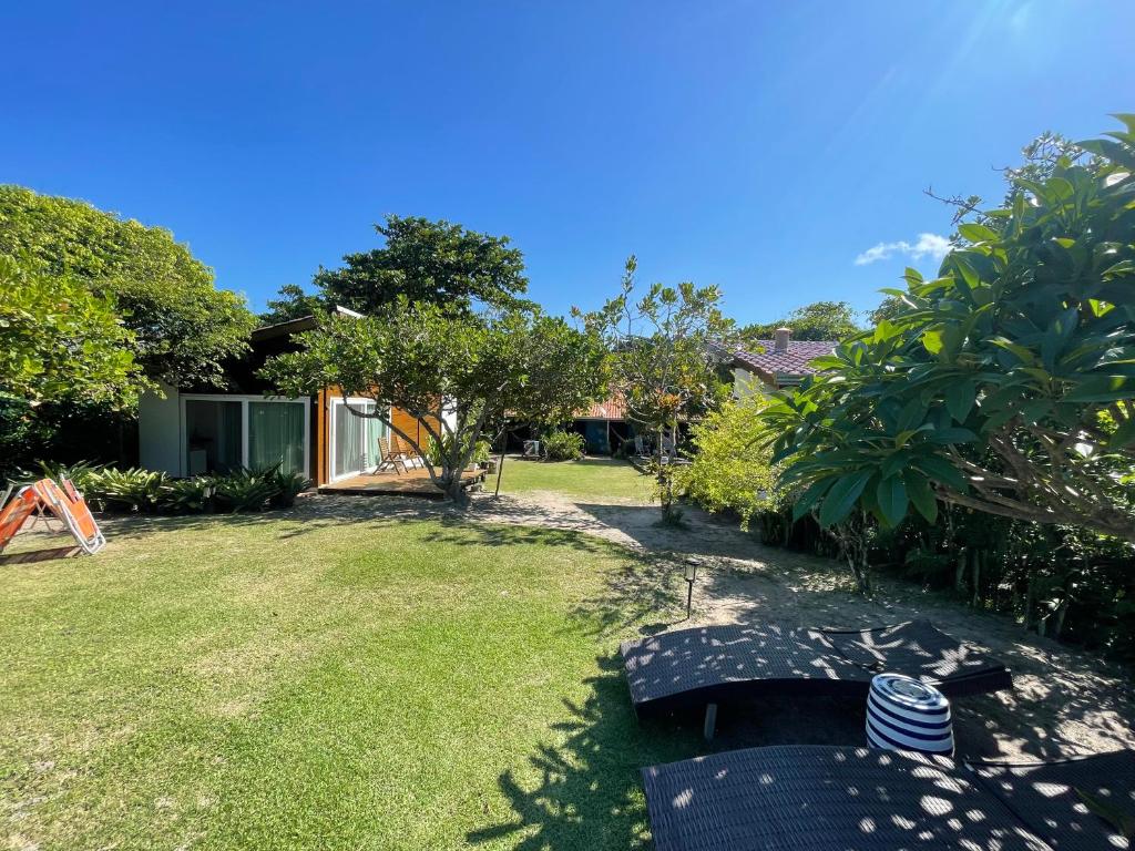 a yard with a house and a garden with trees at Casa da Ilha do Mel - Pousada de Charme in Ilha do Mel