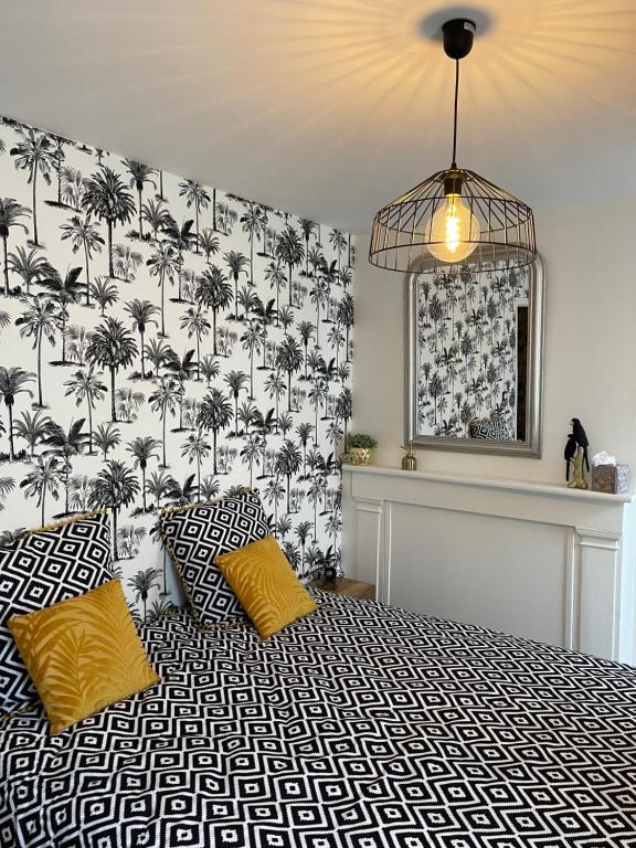 1 dormitorio con 1 cama con papel pintado de palmera en Le Trois Fleurs, en Cherbourg-en-Cotentin