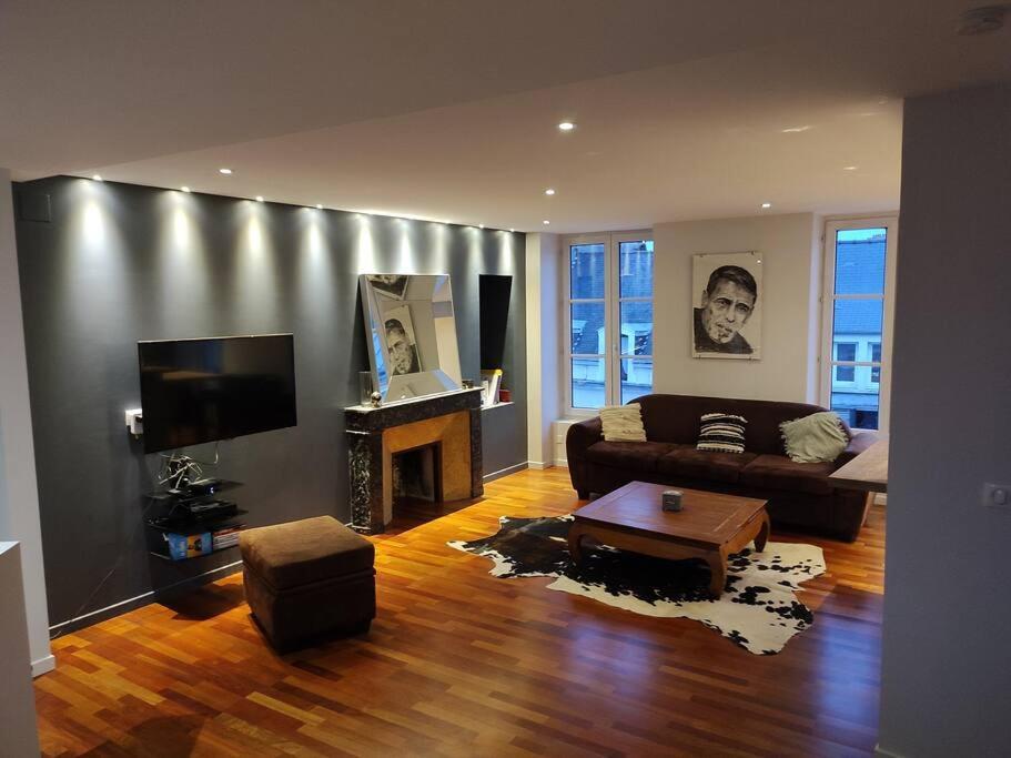 een woonkamer met een bank en een televisie bij Duplex, Le Citadin in Cherbourg en Cotentin