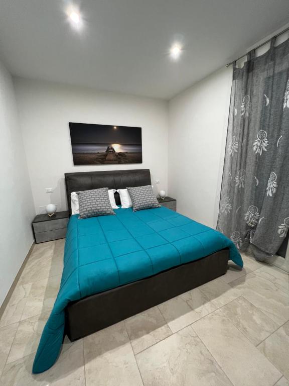 een slaapkamer met een blauw bed in een kamer bij B&B Quintadecima in Uggiano la Chiesa