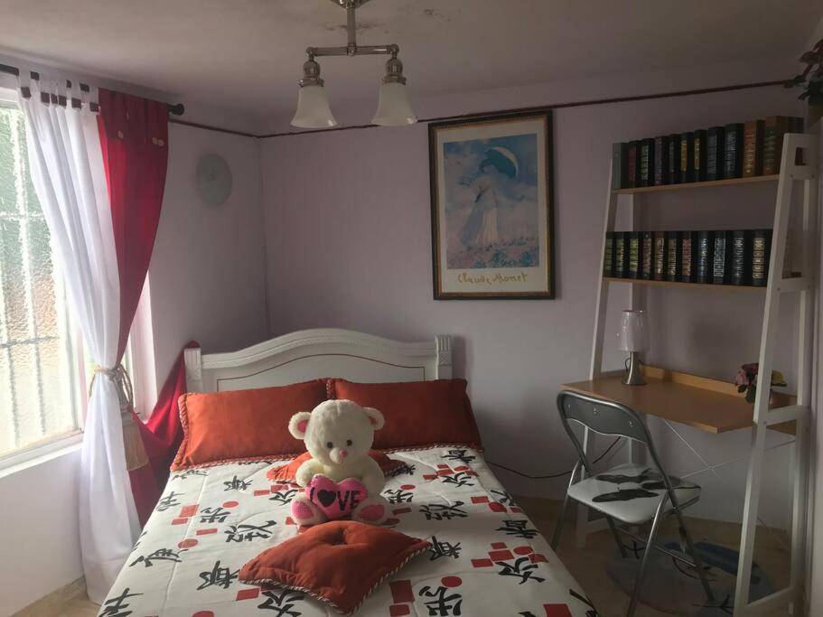 a teddy bear sitting on a bed in a bedroom at CASA ACOGEDORA ACORDE A TU ESTILO in Palmira