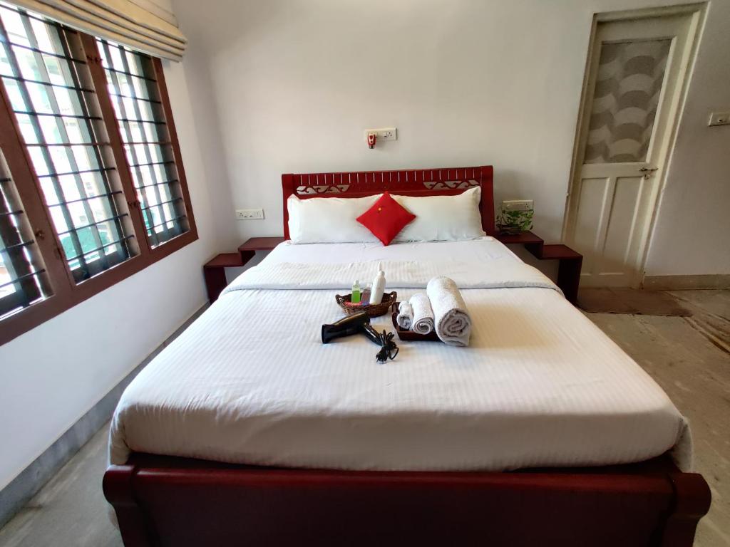 a bedroom with a large bed with shoes on it at The Nook Home in Ernakulam