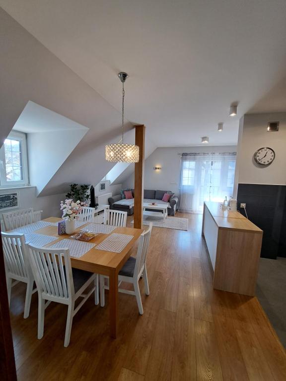 カジミエシュ・ドルニにあるAPARTAMENTY TUŹNIKOWIEのテーブルと椅子のあるダイニングルームとリビングルーム