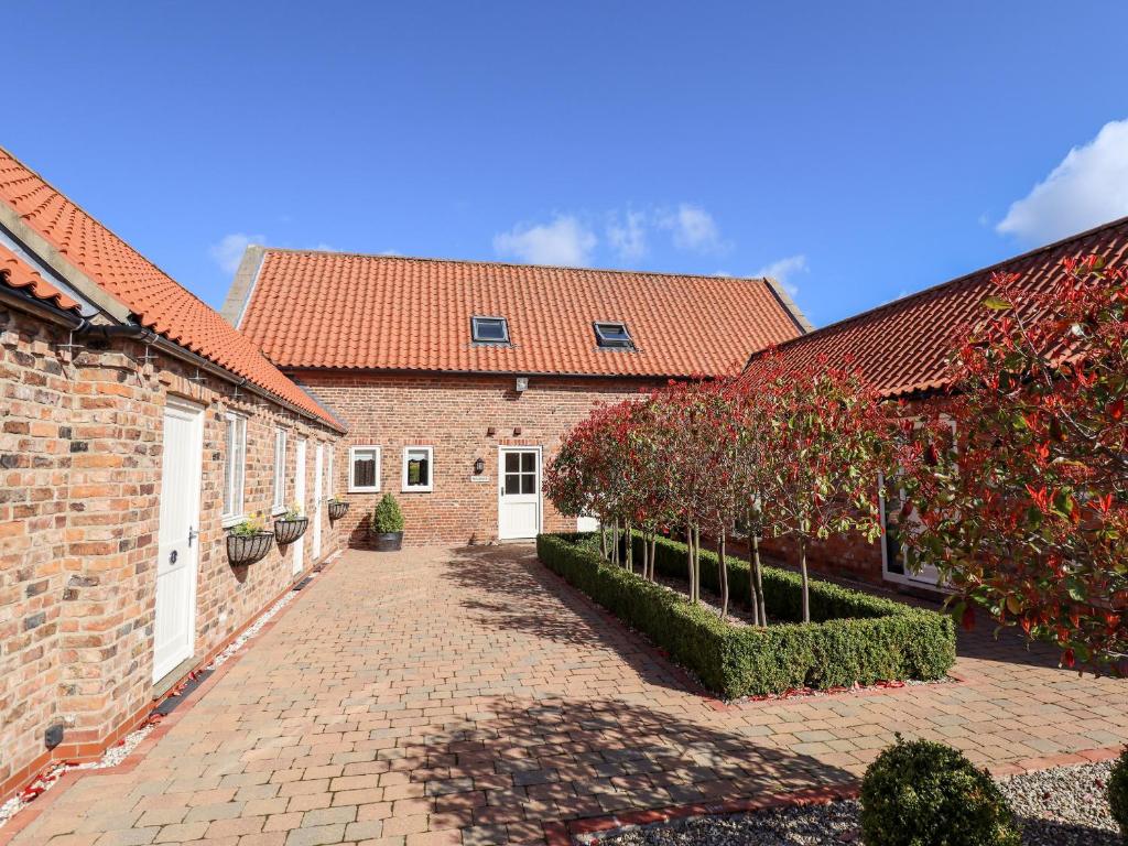 a brick building with a brick walkway between two buildings at Nursery Cottage in Louth
