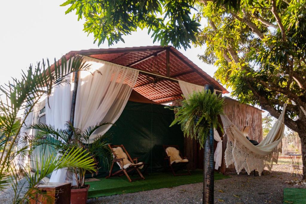 a green tent with a hammock in a garden at Lambú Ecoturismo in Cidade Ocidental